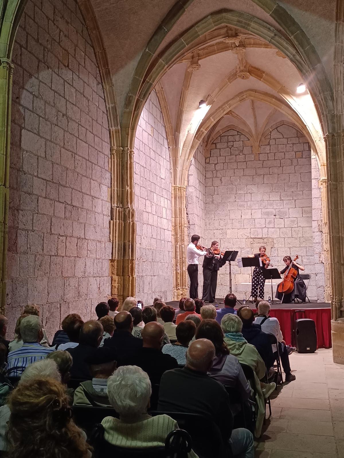 Aralar Quartet en concierto ante el público bajo los arcos de una iglesia de piedra