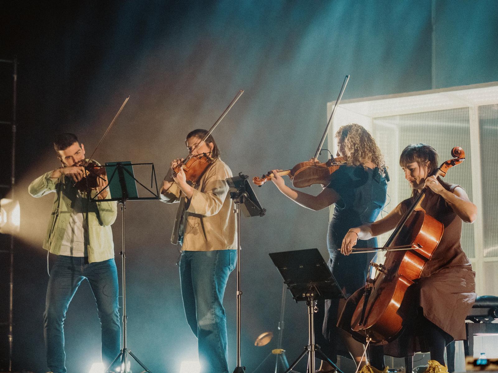 Los cuatro músicos de Aralar Quartet tocando bajo las luces de un escenario